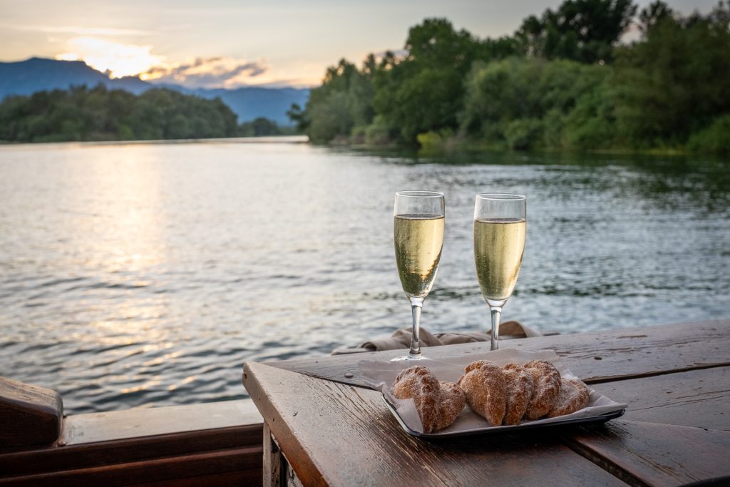 A glass of wine and a sweet pastry by the water in Catalonia